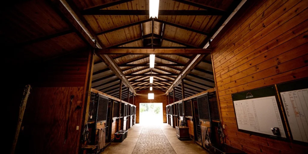 Wood-lined aisle of the custom 16-stall barn