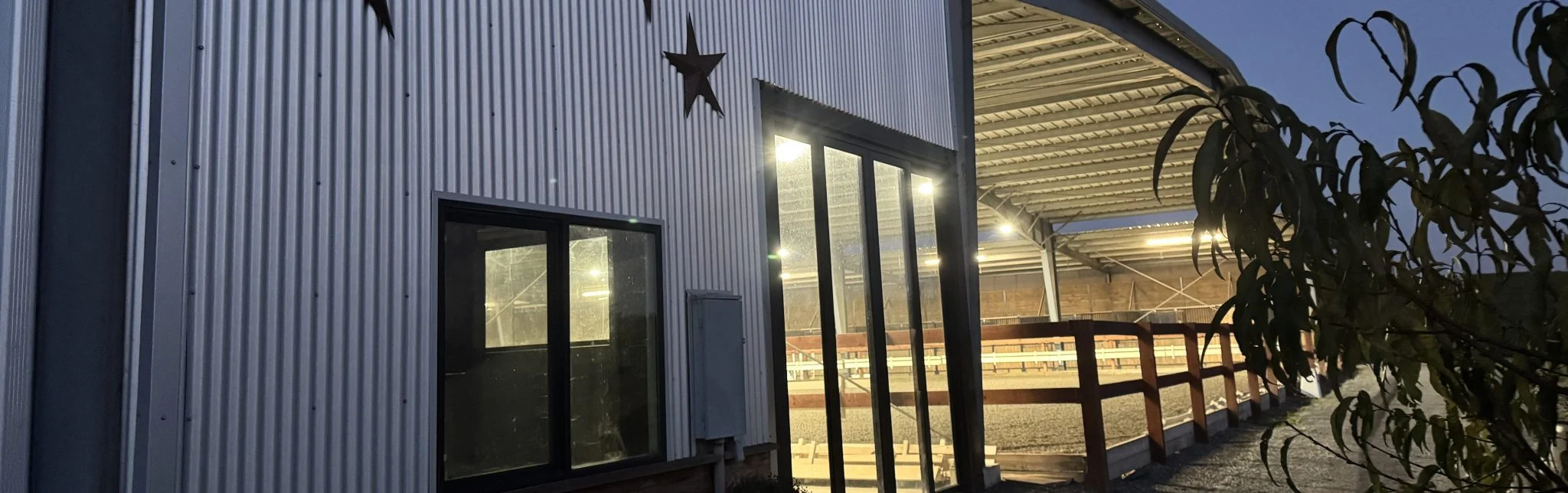Jaz Creek covered arena complex lit at dusk