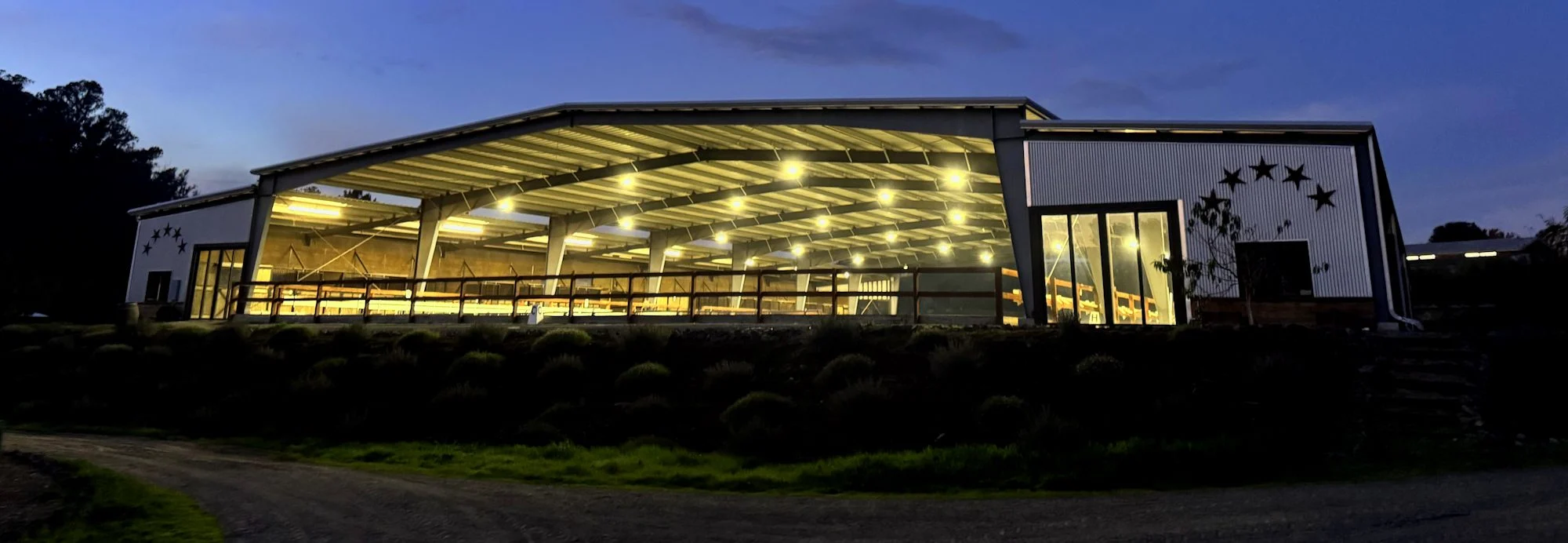 Jaz Creek’s covered riding arena lit at dusk