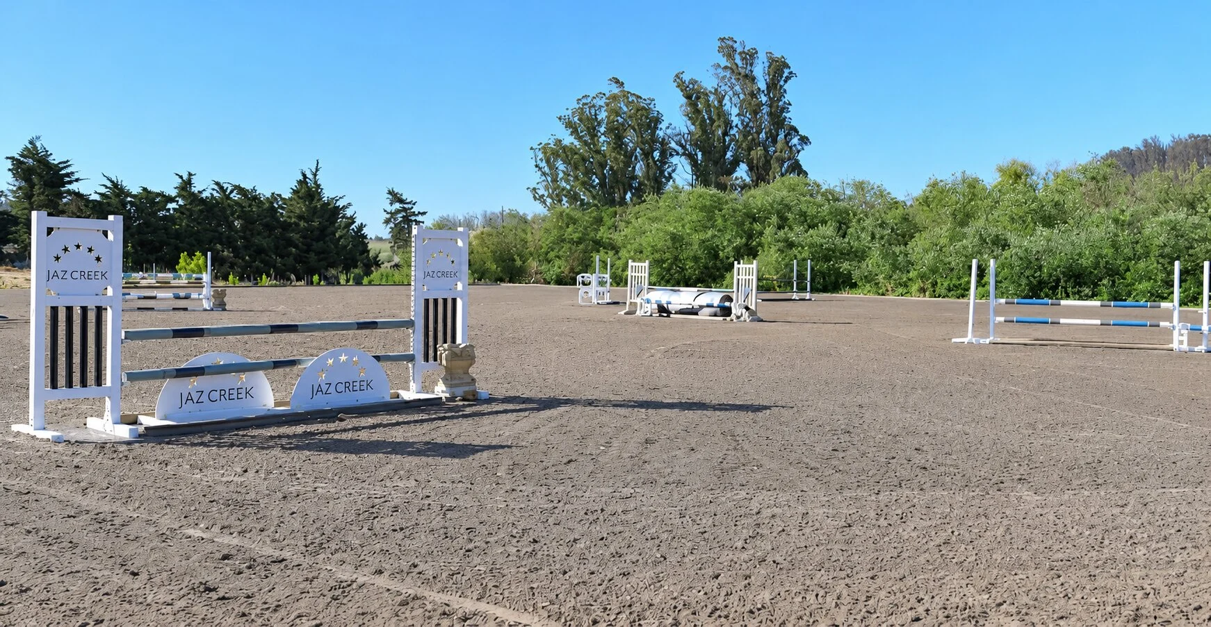 Outdoor jumping arena at Jaz Creek with Jaz Creek jump standards